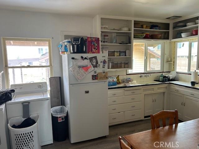 12758 5th St, Yucaipa, CA 92399 - kitchen featuring freestanding refrigerator, washer / dryer, white cabinets, dark wood-type flooring, and light countertops