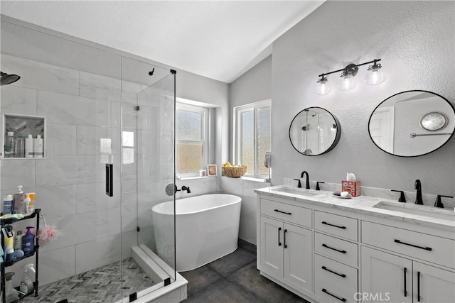 39985 Falcon Way, Murrieta, CA 92562 - bathroom with vaulted ceiling, a shower stall, double vanity, a freestanding bath, and a textured wall