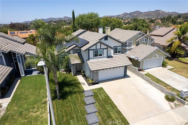 39985 Falcon Way, Murrieta, CA 92562 - view of front facade with solar panels, concrete driveway, a mountain view, stone siding, and a residential view