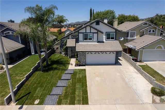 39985 Falcon Way, Murrieta, CA 92562 - view of front facade featuring driveway, a chimney, an attached garage, a front yard, and stone siding