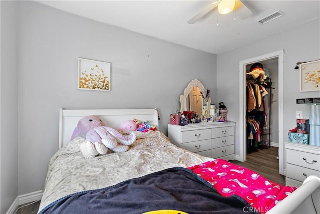 39985 Falcon Way, Murrieta, CA 92562 - bedroom with a spacious closet, wood finished floors, baseboards, a closet, and a ceiling fan