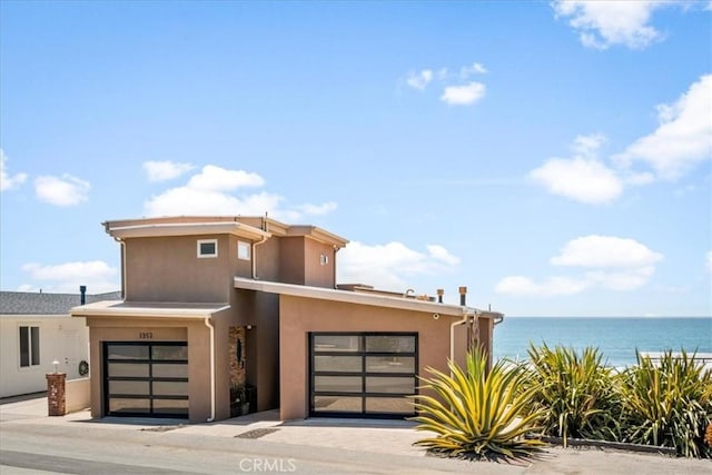 3352 Studio Dr, Cayucos, CA 93430 - view of front facade with stucco siding, a water view, and a garage