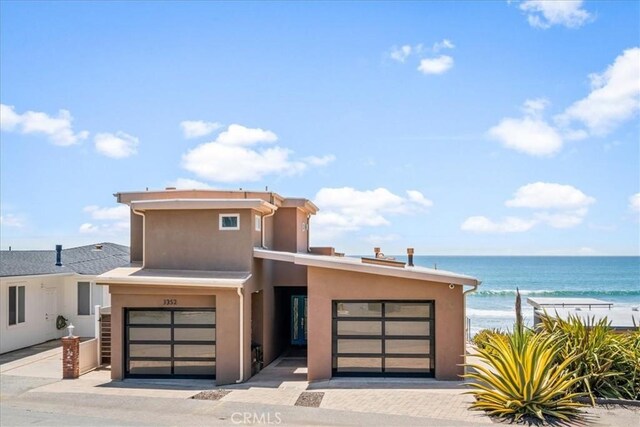 3352 Studio Dr, Cayucos, CA 93430 - view of front of home featuring stucco siding, a garage, and a water view
