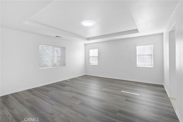 13153 Stanton Dr, Rancho Cucamonga, CA 91739 - empty room featuring a raised ceiling, wood finished floors, and baseboards