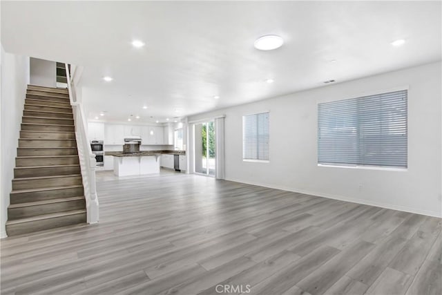 13153 Stanton Dr, Rancho Cucamonga, CA 91739 - unfurnished living room with light wood-style floors, stairs, recessed lighting, and baseboards