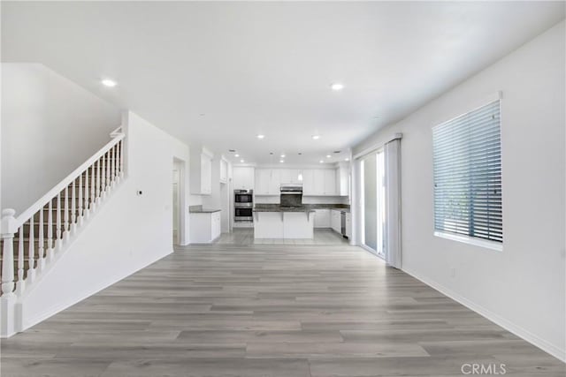 13153 Stanton Dr, Rancho Cucamonga, CA 91739 - unfurnished living room with stairway, recessed lighting, light wood-style floors, and baseboards