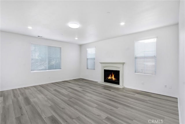 13153 Stanton Dr, Rancho Cucamonga, CA 91739 - unfurnished living room featuring a warm lit fireplace, wood finished floors, healthy amount of natural light, baseboards, and recessed lighting