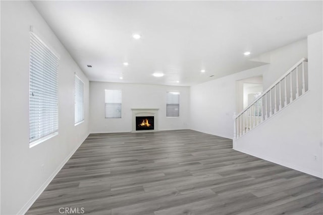 13153 Stanton Dr, Rancho Cucamonga, CA 91739 - unfurnished living room featuring wood finished floors, recessed lighting, stairway, a lit fireplace, and baseboards