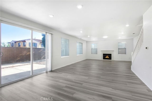 13153 Stanton Dr, Rancho Cucamonga, CA 91739 - unfurnished living room featuring wood finished floors, plenty of natural light, a warm lit fireplace, recessed lighting, and baseboards