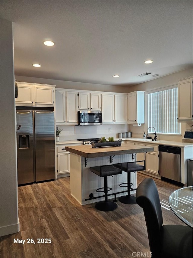 200 Janzen Way, Hemet, CA 92545 - kitchen featuring stainless steel appliances, butcher block counters, dark wood-type flooring, white cabinetry, and a kitchen breakfast bar