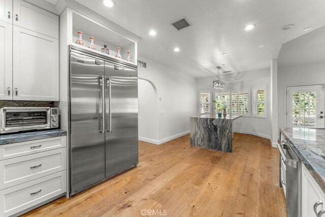 2189 Myers St, Riverside, CA 92503 - kitchen with built in refrigerator, baseboards, recessed lighting, light wood finished floors, and dark stone counters