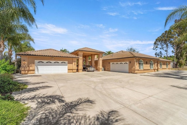 2189 Myers St, Riverside, CA 92503 - mediterranean / spanish-style home featuring stucco siding, a tiled roof, driveway, and a garage