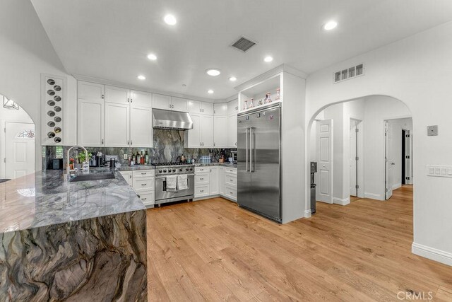2189 Myers St, Riverside, CA 92503 - kitchen with premium appliances, a sink, arched walkways, under cabinet range hood, and stone counters