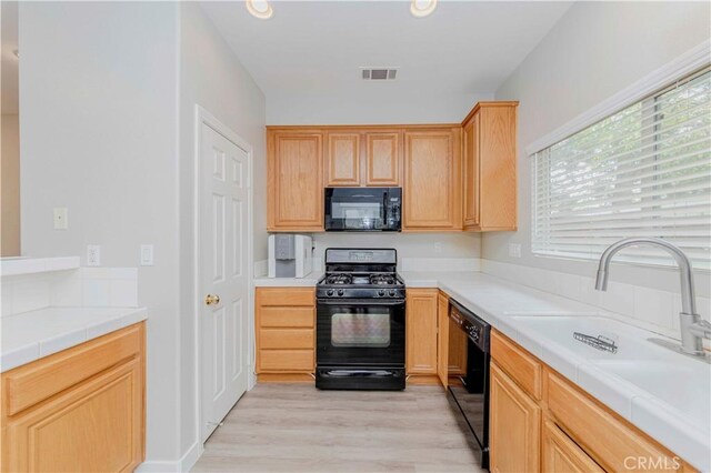 9135 W Rancho Park Cir, Rancho Cucamonga, CA 91730 - kitchen featuring black appliances, light wood-style floors, a sink, light brown cabinets, and tile countertops