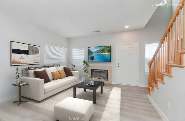 9135 W Rancho Park Cir, Rancho Cucamonga, CA 91730 - living area with stairs, light wood-style flooring, a tiled fireplace, and recessed lighting