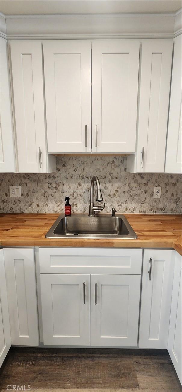 5818 Tyler St, Riverside, CA 92503 - kitchen with butcher block countertops, a sink, white cabinetry, and tasteful backsplash
