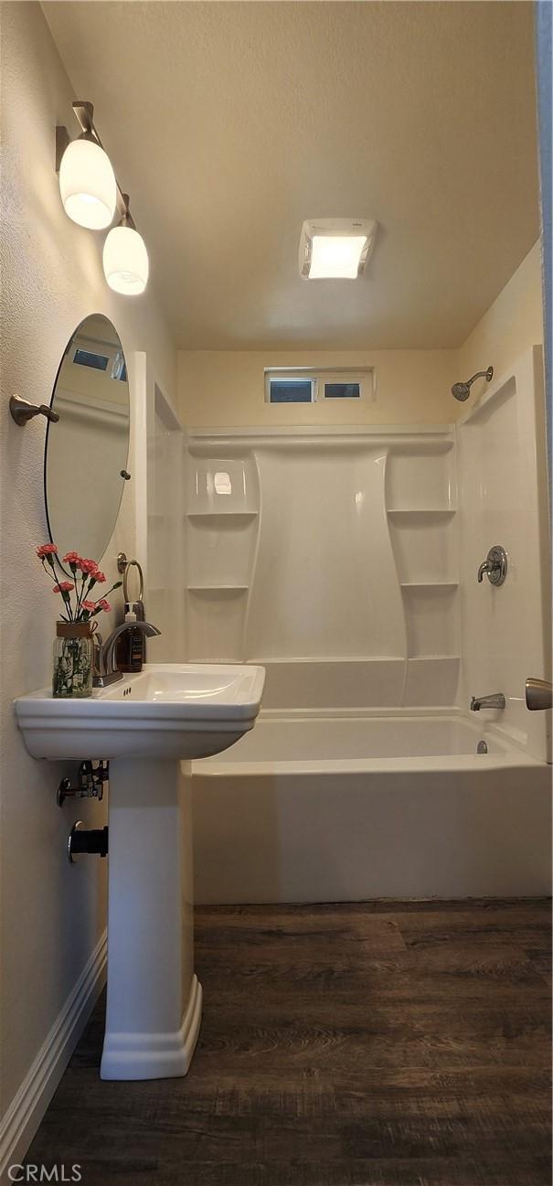 5818 Tyler St, Riverside, CA 92503 - full bath featuring wood finished floors, tub / shower combination, and baseboards