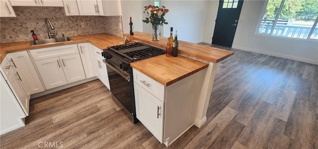 5818 Tyler St, Riverside, CA 92503 - kitchen with butcher block counters, a sink, black gas range oven, a peninsula, and decorative backsplash