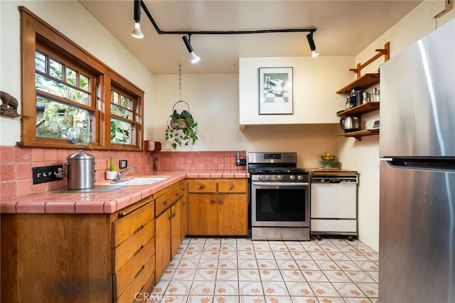 125 W 11th St, Claremont, CA 91711 - kitchen with appliances with stainless steel finishes, rail lighting, tasteful backsplash, open shelves, and tile counters