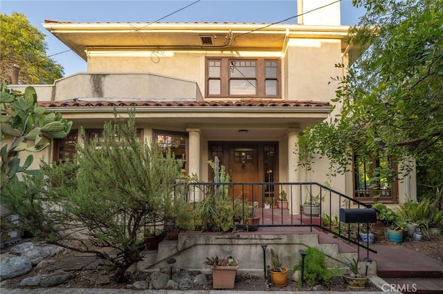 125 W 11th St, Claremont, CA 91711 - mediterranean / spanish house featuring a porch, stucco siding, and a chimney