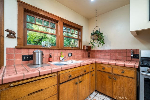 125 W 11th St, Claremont, CA 91711 - kitchen featuring a sink, stainless steel gas range oven, decorative backsplash, and brown cabinets