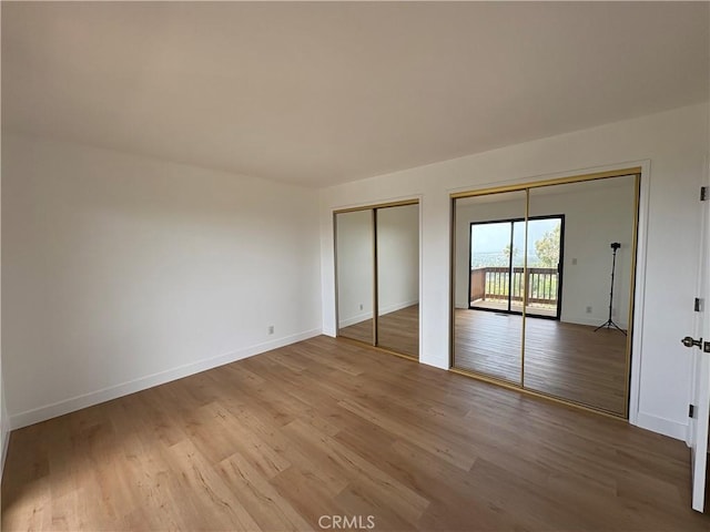 12070 Rideout Way, Whittier, CA 90601 - unfurnished bedroom featuring wood finished floors, baseboards, multiple closets, and access to outside