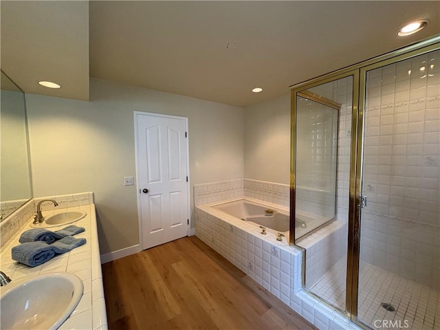 12070 Rideout Way, Whittier, CA 90601 - bathroom featuring a bath, wood finished floors, double vanity, a stall shower, and recessed lighting