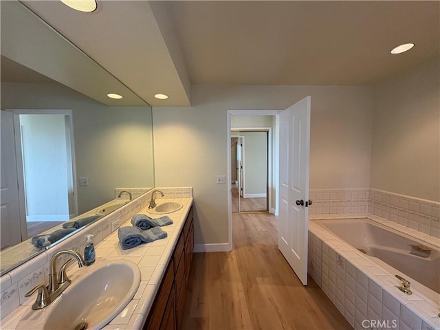 12070 Rideout Way, Whittier, CA 90601 - bathroom with wood finished floors, double vanity, a garden tub, recessed lighting, and baseboards