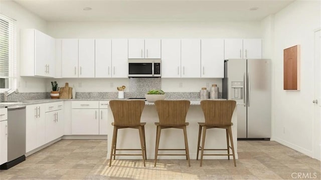 14118 Columbia St, Hesperia, CA 92345 - kitchen with stainless steel appliances, a center island, a breakfast bar, white cabinetry, and light stone countertops
