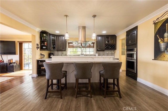 724 Forestview Ave, La Puente, CA 91746 - kitchen featuring double oven, island exhaust hood, decorative backsplash, glass insert cabinets, and a kitchen breakfast bar