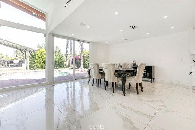 12410 Mclennan Ave, Granada Hills, CA 91344 - dining room with light marble finish flooring, recessed lighting, and floor to ceiling windows