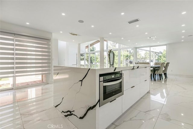 12410 Mclennan Ave, Granada Hills, CA 91344 - kitchen with oven, modern cabinets, white cabinetry, recessed lighting, and a large island