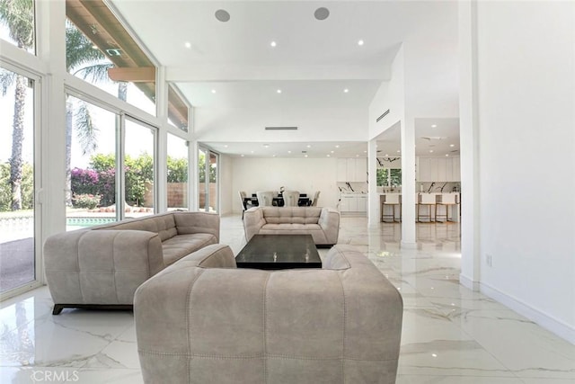 12410 Mclennan Ave, Granada Hills, CA 91344 - living area featuring light marble finish floors, healthy amount of natural light, beam ceiling, recessed lighting, and a high ceiling