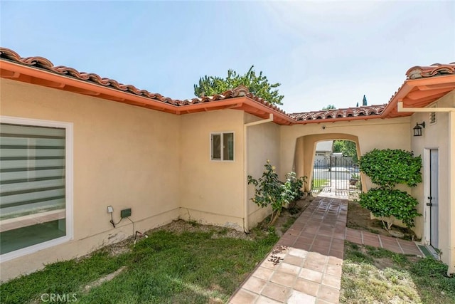 12410 Mclennan Ave, Granada Hills, CA 91344 - view of exterior entry with stucco siding, a tiled roof, and a gate