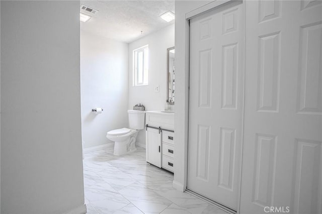 502 S Rosario Ave, San Jacinto, CA 92583 - bathroom with marble finish floors, vanity, toilet, baseboards, and a textured ceiling