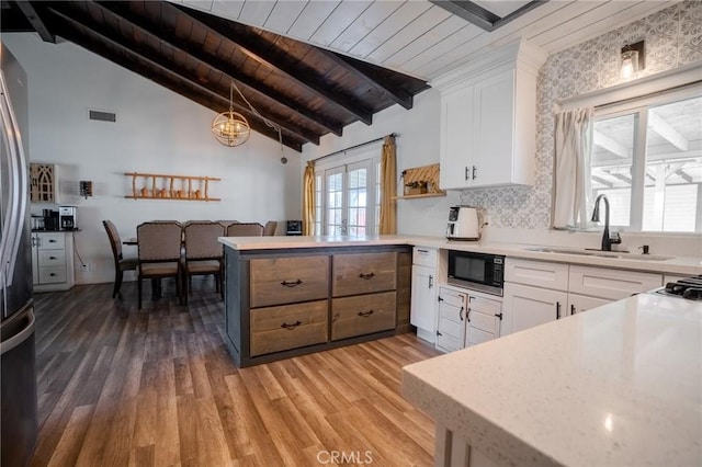 502 S Rosario Ave, San Jacinto, CA 92583 - kitchen with a sink, built in microwave, wood ceiling, a peninsula, and light wood-type flooring