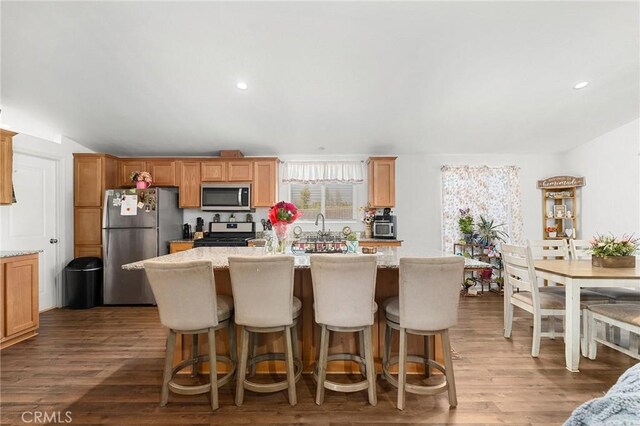 1863 Norwood Dr, Paradise, CA 95969 - kitchen featuring appliances with stainless steel finishes, a kitchen island with sink, wood finished floors, light stone countertops, and recessed lighting