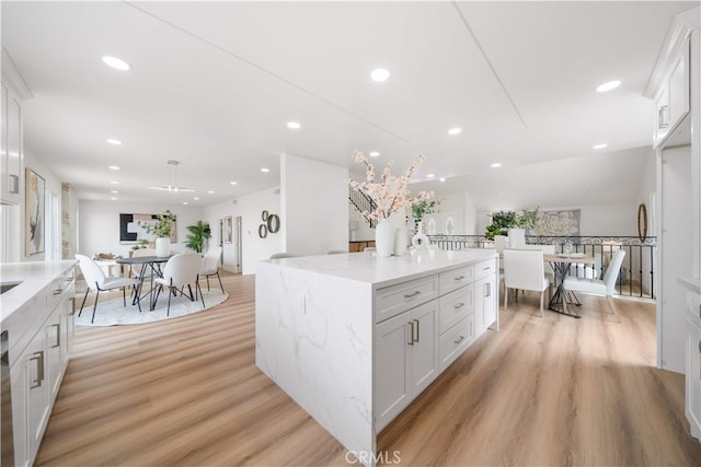 17585 Candela Dr, Rowland Heights, CA 91748 - kitchen featuring light wood finished floors, white cabinets, recessed lighting, a center island, and light stone counters
