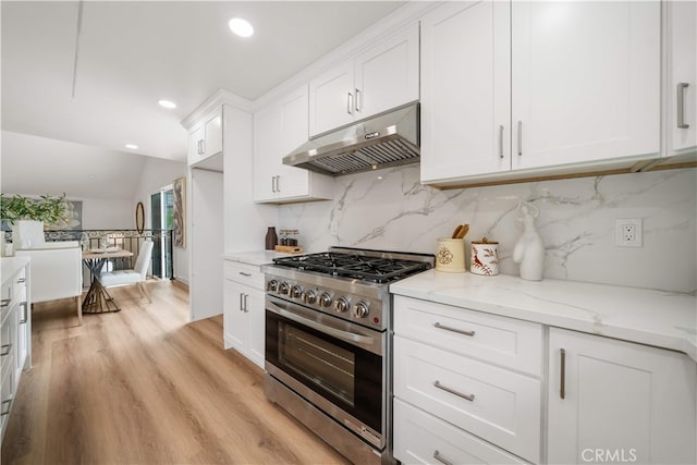 17585 Candela Dr, Rowland Heights, CA 91748 - kitchen featuring stainless steel range with gas stovetop, under cabinet range hood, decorative backsplash, white cabinetry, and light wood-style floors