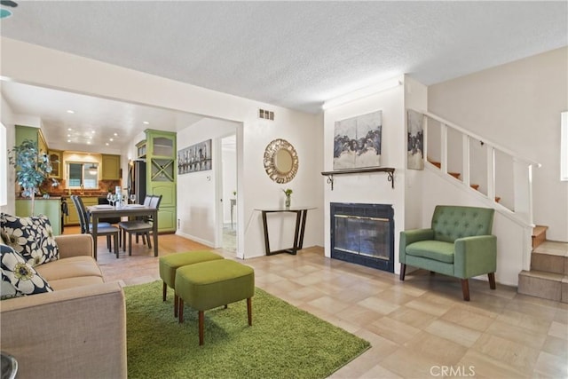 14906 Grevillea Ave, Lawndale, CA 90260 - living room with stairway, a glass covered fireplace, and a textured ceiling