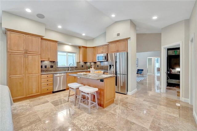1806 Lake St, Huntington Beach, CA 92648 - kitchen with stainless steel appliances, a sink, a center island, backsplash, and a kitchen bar