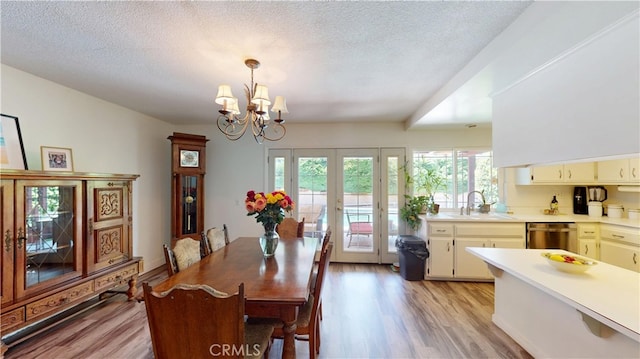 8776 Holly St, Rancho Cucamonga, CA 91701 - dining space featuring french doors, light wood finished floors, a chandelier, and a textured ceiling
