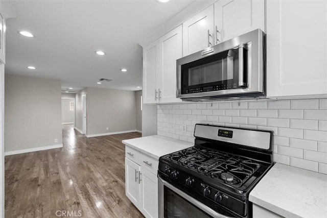 13339 Bonanza St, Arleta, CA 91331 - kitchen featuring appliances with stainless steel finishes, recessed lighting, white cabinetry, baseboards, and light wood-style flooring
