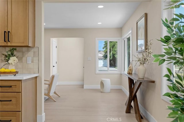 11091 Ranger Dr, Los Alamitos, CA 90720 - kitchen featuring decorative backsplash, light countertops, light wood-type flooring, baseboards, and recessed lighting