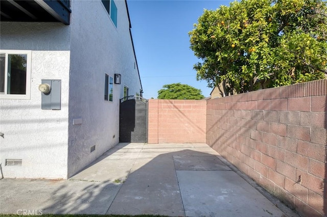 11091 Ranger Dr, Los Alamitos, CA 90720 - view of side of home featuring crawl space, a fenced backyard, stucco siding, and a patio