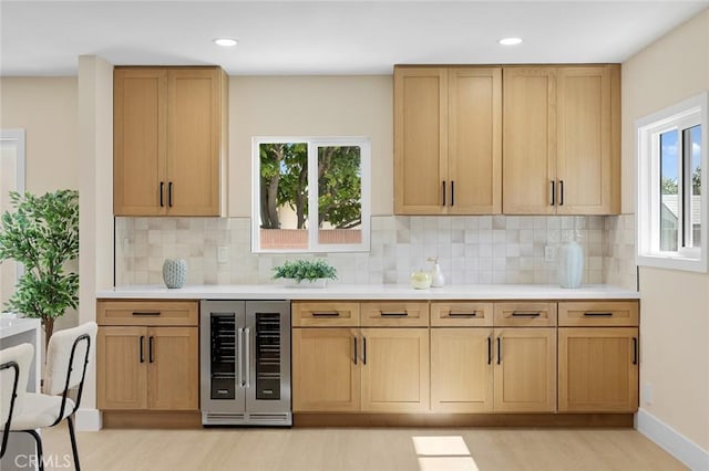 11091 Ranger Dr, Los Alamitos, CA 90720 - kitchen featuring wine cooler, light wood finished floors, light countertops, decorative backsplash, and healthy amount of natural light