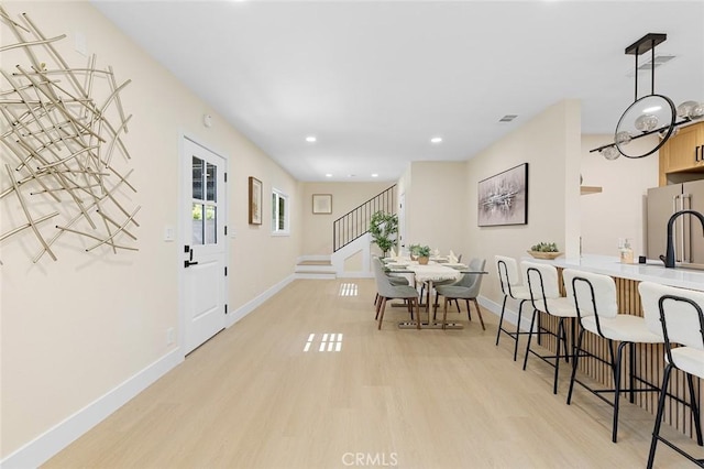11091 Ranger Dr, Los Alamitos, CA 90720 - dining space with light wood finished floors, stairway, baseboards, and recessed lighting