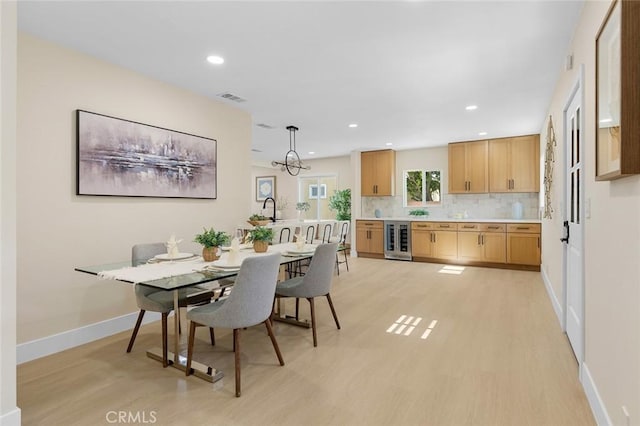 11091 Ranger Dr, Los Alamitos, CA 90720 - dining area with wine cooler, light wood-type flooring, baseboards, and recessed lighting