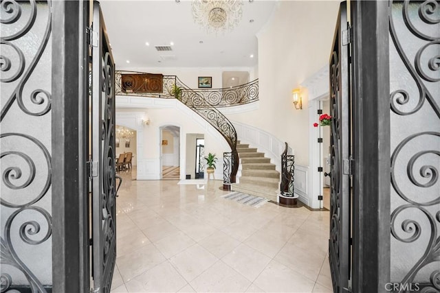 553 Woodward Blvd, Pasadena, CA 91107 - foyer entrance featuring arched walkways, stairway, light tile patterned floors, a chandelier, and ornamental molding