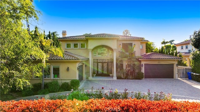 553 Woodward Blvd, Pasadena, CA 91107 - mediterranean / spanish-style house featuring a chimney, an attached garage, stucco siding, decorative driveway, and a tile roof